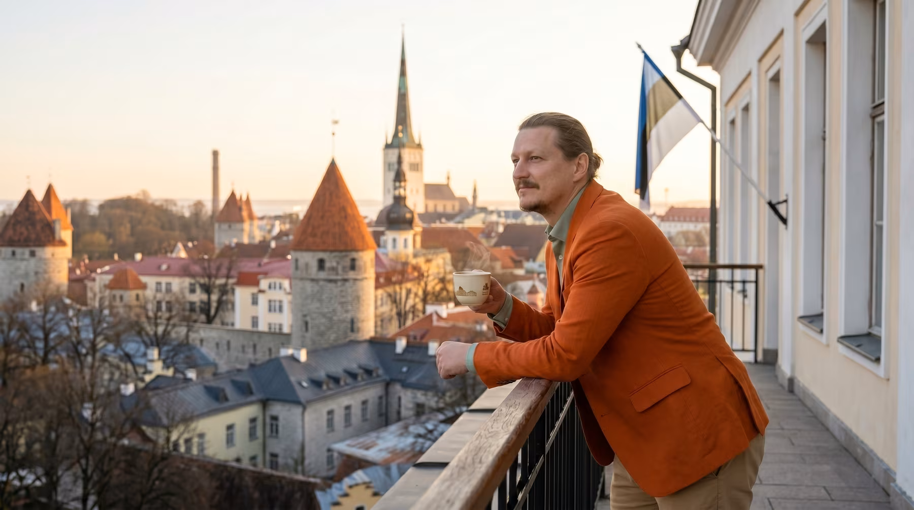 Pavel (Paul) Marr leaning on a balcony with a cup of coffe early in the morning in Tallinn, Estonia.